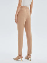 a woman in camel cigarette pants